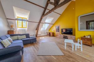 un salon avec un canapé bleu et une télévision dans l'établissement villa de charme Calme et campagne Caution obligatoire swikly, à Coullons