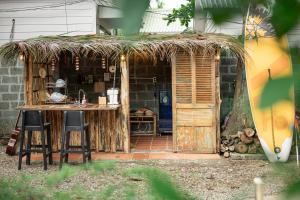 a hut with a table and chairs and a surfboard at Canaan Beach Home in Phú Quốc