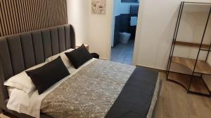 una camera da letto con un letto grande con cuscini neri di CarMa Luxury Rooms a Linguaglossa