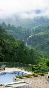 een zwembad met een waterval op de achtergrond bij Ramboda Falls PLC in Ramboda +27 foto's