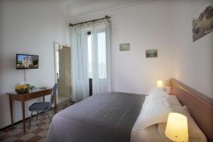 a bedroom with a bed with a desk and a window at Villa Astoria in Taormina