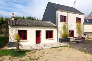 une maison blanche avec des fenêtres rouges et une cour dans l'établissement Domaine Fouet - A 100m du Domaine visite de cave et dégustation gratuite, à Saint-Cyr-en-Bourg