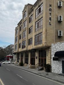 巴库阿尔普酒店 的街道上的建筑物,前面有停车位