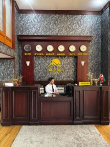 巴库阿尔普酒店 的一名男子站在餐厅柜台后面