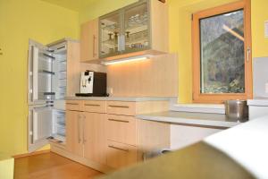 a kitchen with yellow walls and wooden cabinets at Ferienwohnung Ziersch in Vandans