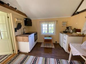 a small kitchen with a sink and a stove at Lite hus i hagen in Malvik