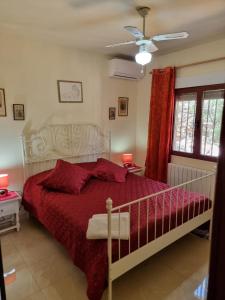 a bedroom with a bed with a red comforter at Casa Katalyna in Orba