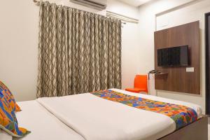 a hotel room with a bed and a tv at FabHotel Executive Pearl Inn - Nr Twin tower in Pune