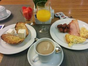 a table with two plates of food and a cup of coffee at Hotel Hayat Palace Johar Town in Lahore