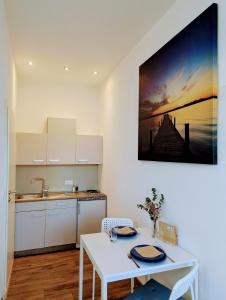 a kitchen with a white table and a sink and a table at Sonniges Appartement in Ansbach in Ansbach
