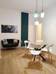 a dining room with a table and chairs and a couch at Regina House al centro di Cagliari in Cagliari
