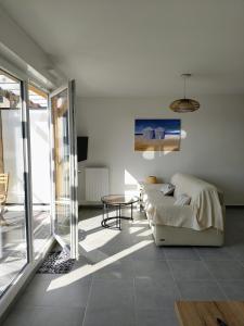 a living room with a couch and a table at Appartement neuf, calme et ensoleillé in Cabourg