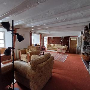 a living room with two couches and a fireplace at The Old Post Office in Coverack