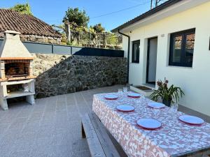 a table with plates on it on a patio at Quinta de Fonte Coberta in Ponte da Barca