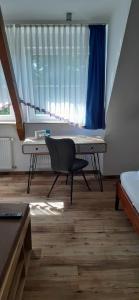 una camera con scrivania e sedia di fronte a una finestra di Hotel-Gasthof Tor zum Steigerwald a Gerolzhofen