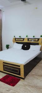 FaizābādShri Balaji Home Stay的卧室里的一张大床，上面躺着一只黑猫 更多8张照片