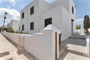 a white house with a white wall and stairs at Casa Queen Vetusta -Pool and Tennis in Arrecife