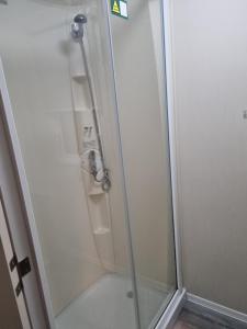 a shower with a glass door in a bathroom at fantasy island in Ingoldmells +9 photos