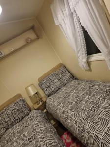 a small bedroom with two beds and a window at fantasy island in Ingoldmells