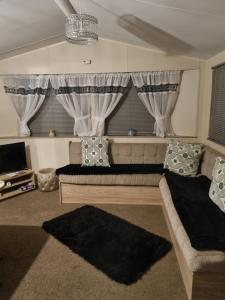 a living room with two beds and a window at fantasy island in Ingoldmells