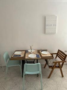 a dining room table with chairs and plates on it at Bonne Chance Apartment Sozopol in Sozopol