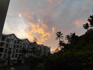 タナ・ラタにあるGolden hill somersqaure 3 bed room islam apartmentのヤシの木や建物が並ぶ街の夕日