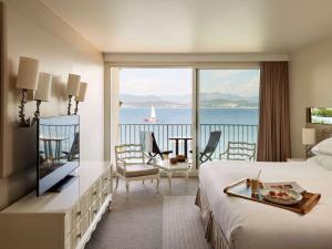 a hotel room with a bed and a view of the ocean at Sofitel Golfe d'Ajaccio Thalassa Sea & Spa in Ajaccio