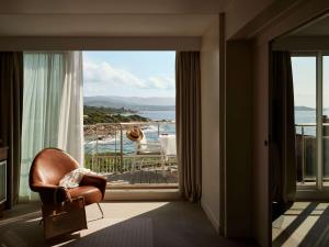 a room with a chair and a view of the ocean at Sofitel Golfe d'Ajaccio Thalassa Sea & Spa in Ajaccio