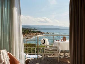 a balcony with a table and a view of the ocean at Sofitel Golfe d'Ajaccio Thalassa Sea & Spa in Ajaccio