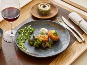 a table with a plate of food and a glass of wine at Sofitel Golfe d'Ajaccio Thalassa Sea & Spa in Ajaccio