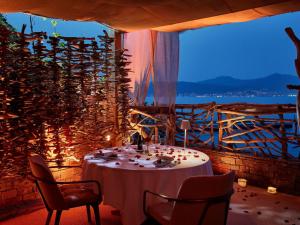 a dining room with a table and chairs and a window at Sofitel Golfe d'Ajaccio Thalassa Sea & Spa in Ajaccio