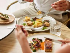 a group of people sitting at a table with plates of food at Sofitel Golfe d'Ajaccio Thalassa Sea & Spa in Ajaccio