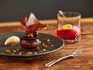 a plate with a dessert on a table with a drink at Sofitel Golfe d'Ajaccio Thalassa Sea & Spa in Ajaccio