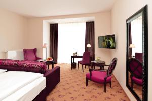 バート・ノイェンアール・アールヴァイラーにあるHotel Villa Sanct Peterのベッド、テーブル、椅子が備わるホテルルームです。