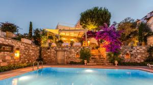 a swimming pool in front of a house at Ipekyol Villa avec Piscine Privée in Çeşme