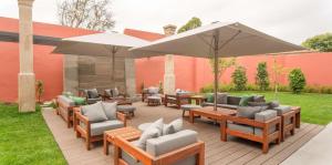 a patio with tables and chairs and an umbrella at NH Porto Jardim in Porto