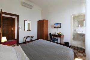 a bedroom with a bed and a bathroom with a sink at Villa Astoria in Taormina
