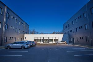 un parcheggio con auto parcheggiate davanti a un edificio di Hostel Optimum Devínska a Devin