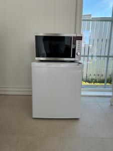 a microwave sitting on top of a white refrigerator at Sjøgata Hagehus in Larvik
