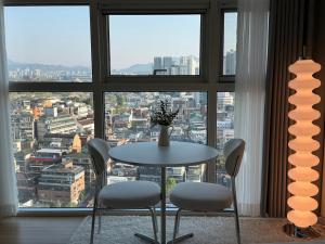 a table and chairs in front of a large window at Seoul Station Studio-City View in Seoul