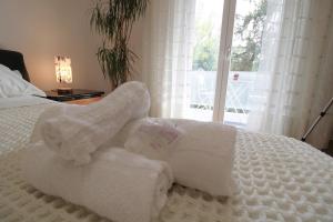 a white bed with a pile of towels on it at Forli con Park view style e comfort in Forlì