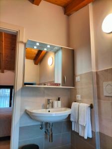 a bathroom with a sink and a mirror and towels at La casa della Ada in Castelnuovo del Garda