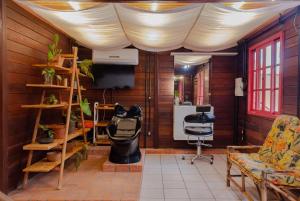 a living room with a white curtain over a room with a chair at Casa EcoSpa, Centrinho da Lagoa da Conceição N550 in Florianópolis