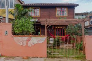 a house with a fence in front of it at Casa EcoSpa, Centrinho da Lagoa da Conceição N550 in Florianópolis