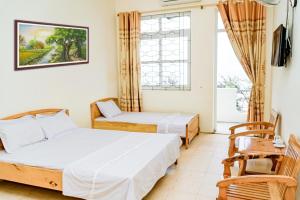 een kamer met twee bedden en een raam bij Khách Sạn Sông Mã Sầm Sơn in Sầm Sơn