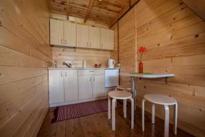 a kitchen with a table and two stools in a cabin at Domki Niegowa Agroturystyka in Niegowa