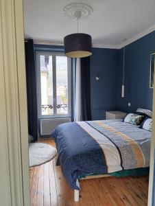 a blue bedroom with a bed and a window at La villa de l'Angle - Maison familiale de charme - jusqu'à 10 voyageurs in Le Mont-Dore