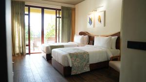 ein Hotelzimmer mit zwei Betten und einem Fenster in der Unterkunft Waterwoods Boutique Resort & Villas Havelock in Havelock Island