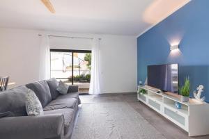 a living room with a couch and a tv at Brisa do Rio - Portimao in Portimão