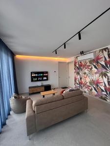 a living room with a couch and a tv at Desibu Collection - The Pearl St Julian's in St Julian's